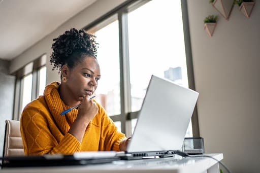 A female woman of color working in front of her laptop.