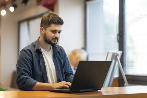 A man working with his laptop on his desk